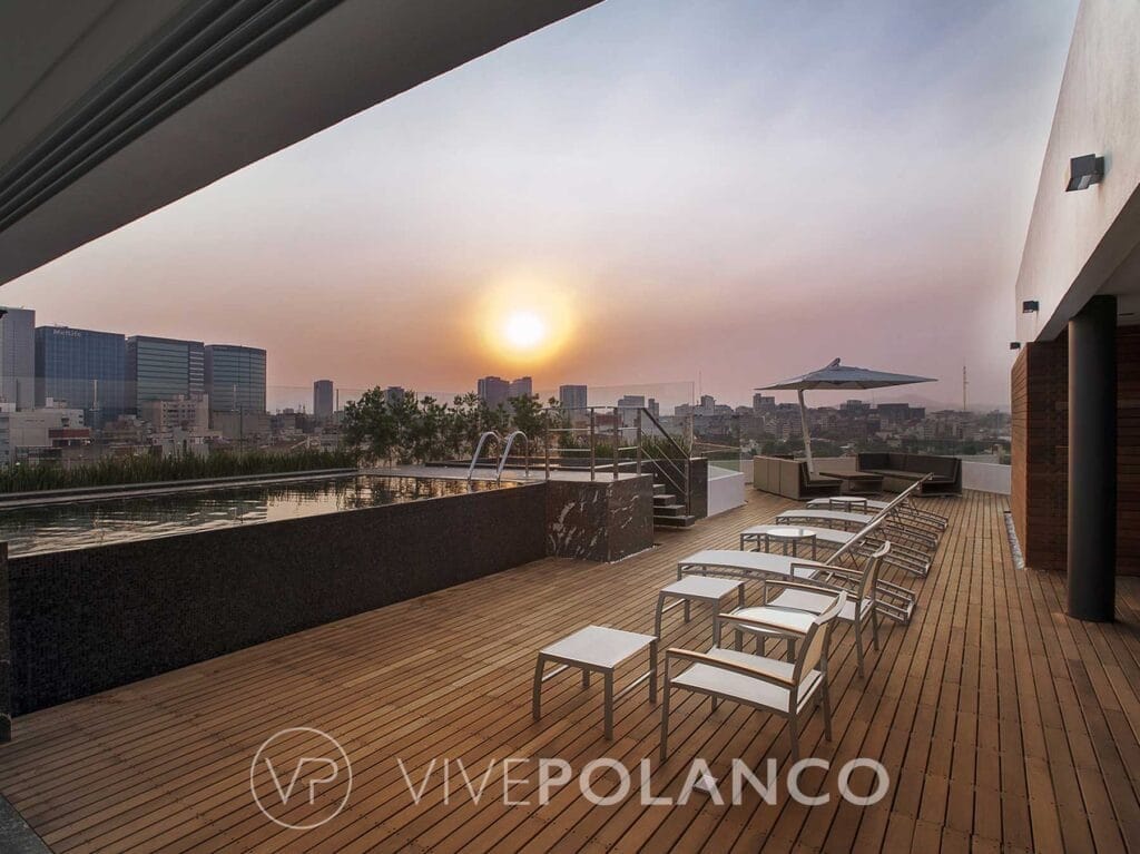 Terraza en rooftop de Emilio Castelar 219 con alberca, deck de madera y sillas lounge al atardecer