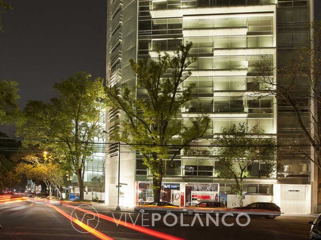 Fachada nocturna iluminada del edificio Emilio Castelar 219 en Polanco con balcones de cristal