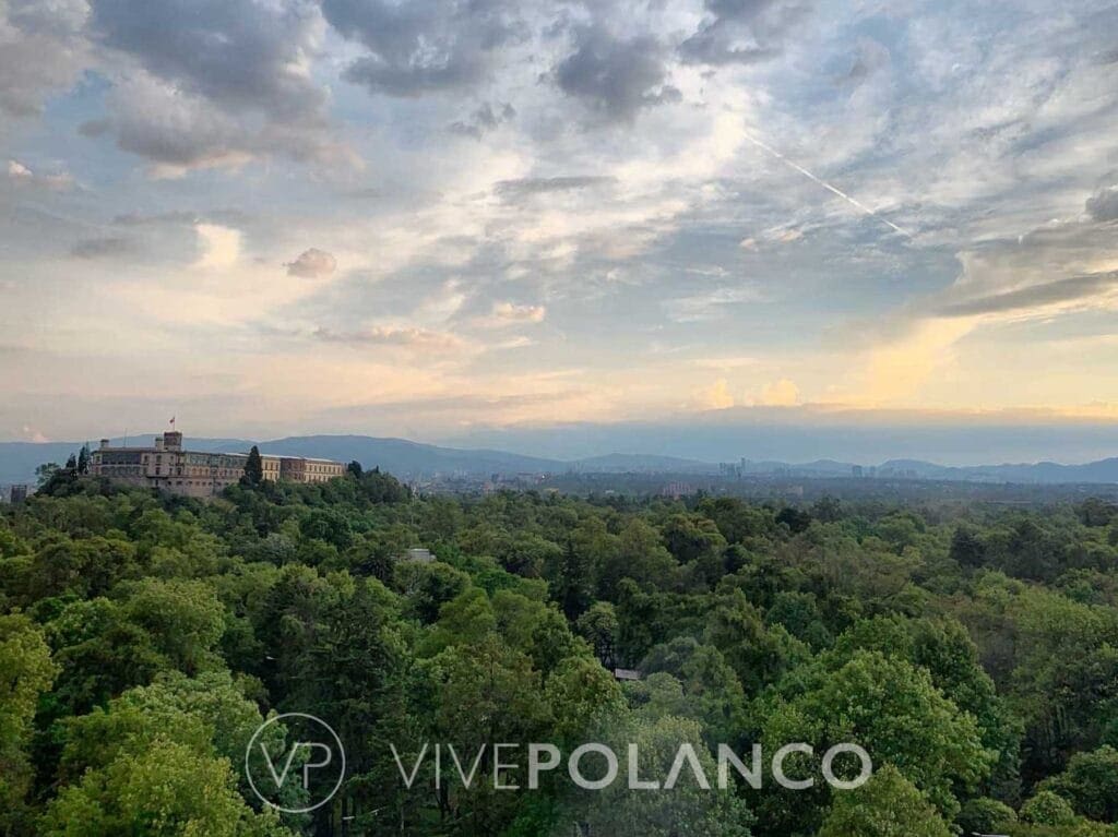 Vista panorámica aérea del Bosque de Chapultepec mostrando vegetación densa y edificio histórico al atardecer
