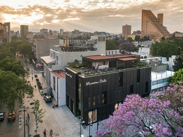 Vista aérea de la Avenida Presidente Masaryk en Polanco con edificios comerciales y jacarandas en flor