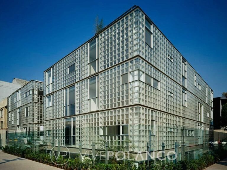 Edificio residencial contemporáneo con fachada de bloques de vidrio y ventanas asimétricas bajo cielo azul en Alejandro Dumas 207, Polanco