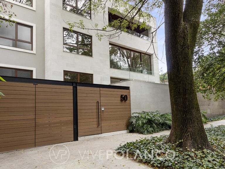 Casa moderna de tres pisos con fachada blanca, ventanas amplias y barda de madera horizontal con número 50 en Anatole France 50, Polanco