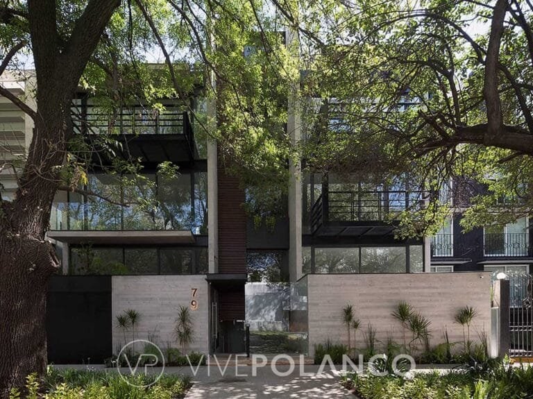 Fachada de casa moderna de tres niveles con ventanales amplios, elementos de madera y concreto rodeada de árboles en Calderón de la Barca 79, Polanco