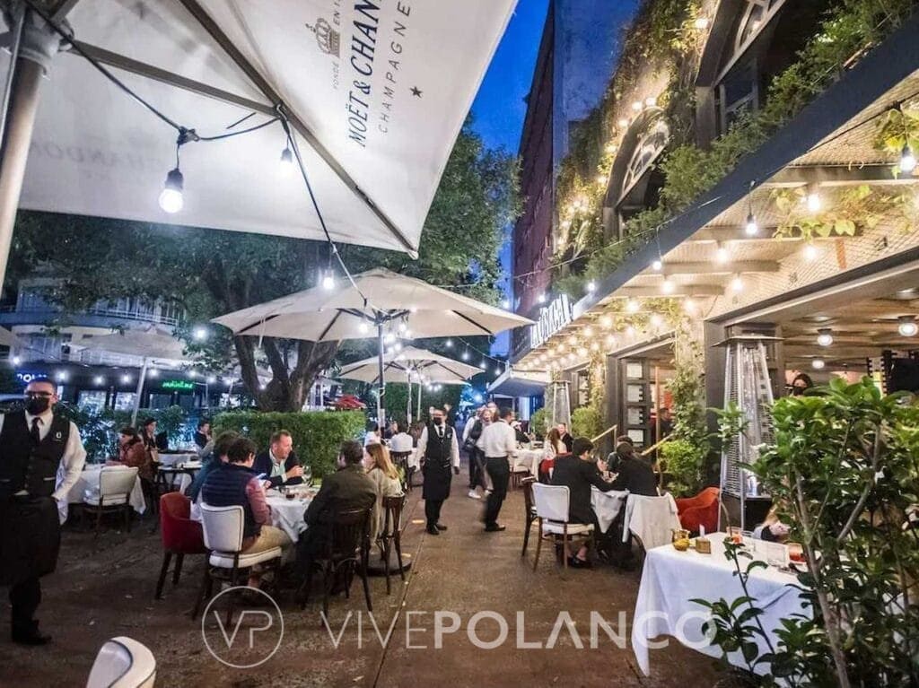 Terraza de restaurante en Polanquito con comensales cenando por la noche bajo sombrillas iluminadas