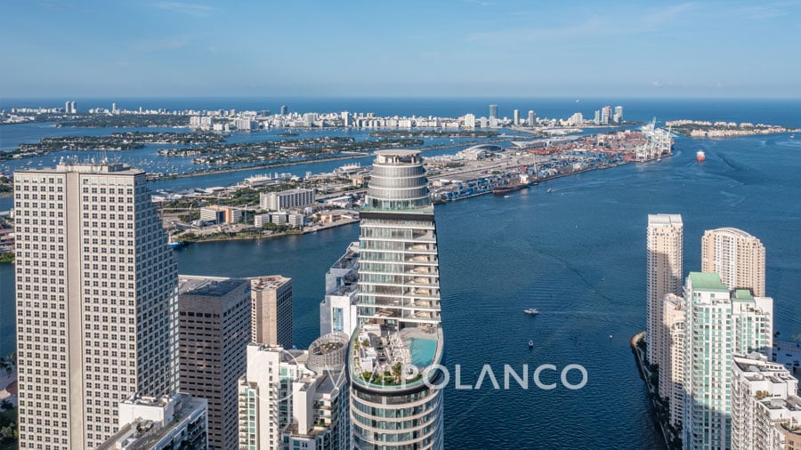 aston martin residences Aerial view of a modern skyscraper along the bustling waterfront with ocean and city views