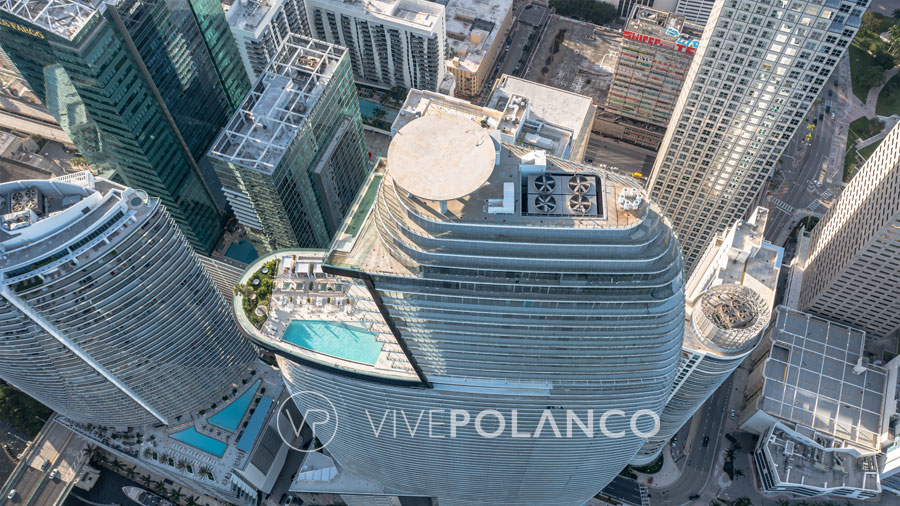 Aston Martin Residences' Aerial view of a modern high-rise building with rooftop pool in a bustling city