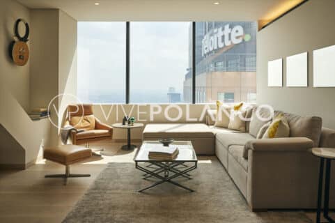 Elegant living room with panoramic city views, featuring a plush sofa and contemporary decor.