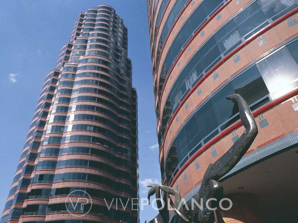 Vista angular de dos torres residenciales curvas con fachada de ladrillo y cristal en Polanco