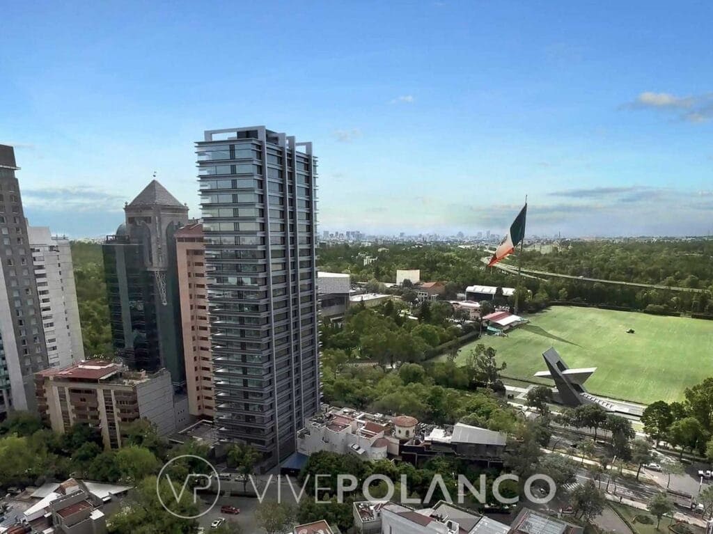 Vista aérea de Polanco con torre residencial moderna, campo deportivo y áreas verdes urbanas