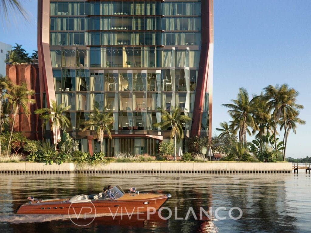 Edificio Villa Miami con fachada de cristal y estructura rojiza, rodeado de palmeras junto al agua