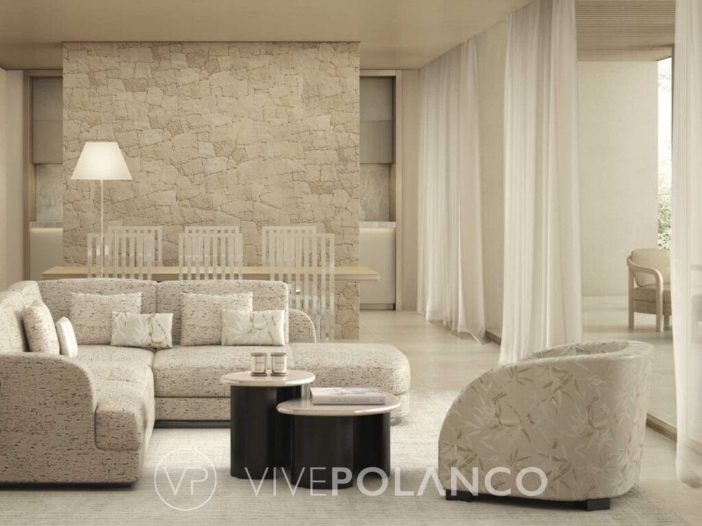 Sala de estar elegante en Armani Residences Masaryk con sofá beige, muro de piedra natural y cortinas blancas en Armani Residences Masaryk Vive Polanco, Polanco