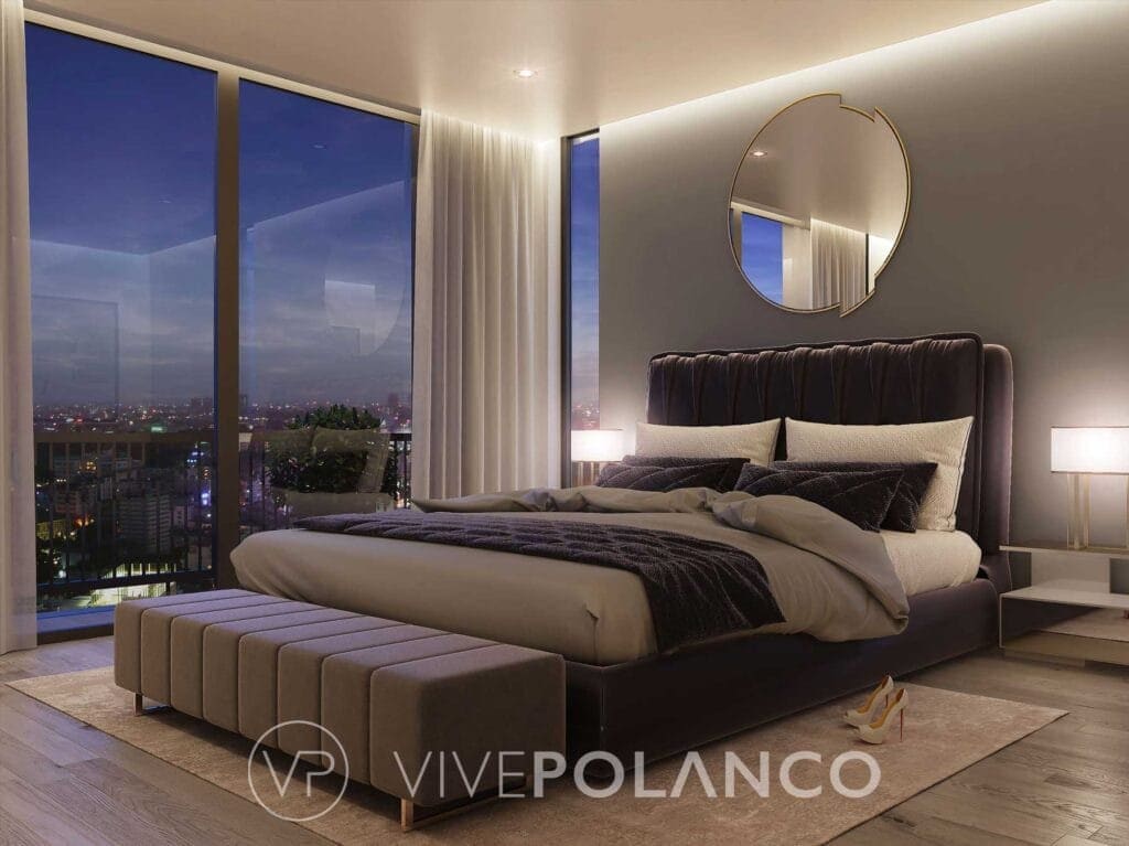 Recámara principal elegante con cama tapizada, ventanales amplios y vista nocturna a la ciudad