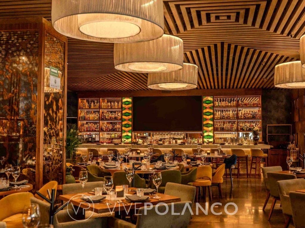 Elegante restaurante con decoración de madera, lámparas diseño y mesas preparadas para cena en Polanco Restaurants, Polanco