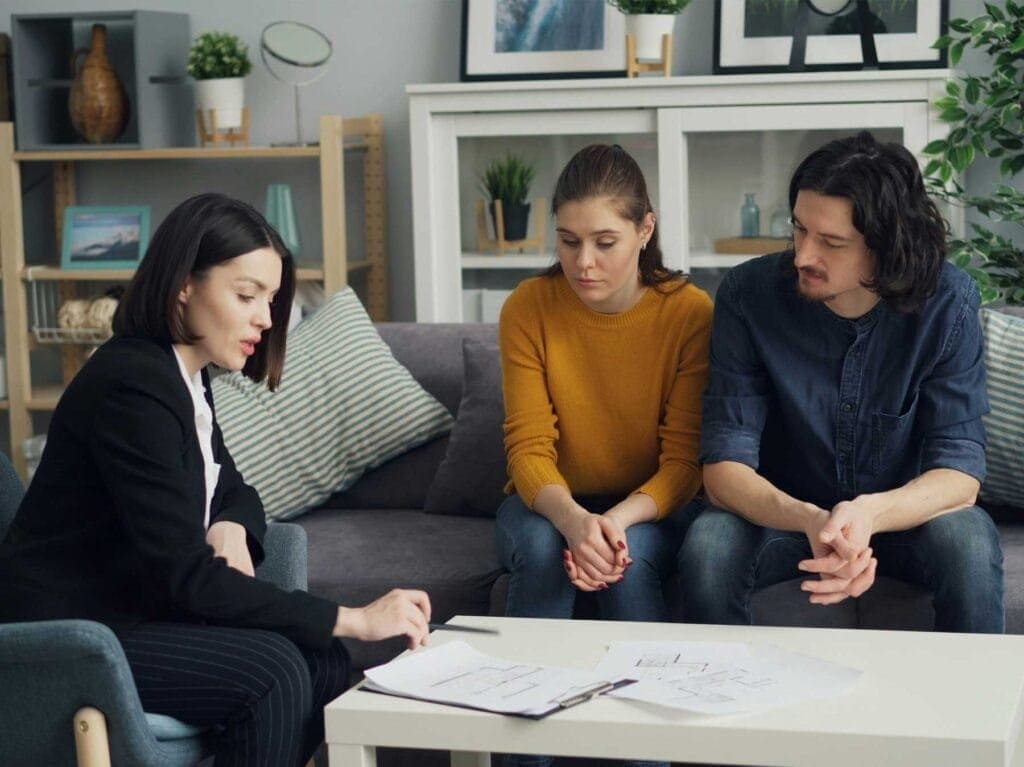 Agente inmobiliaria presenta documentos legales a pareja joven durante consulta profesional en Legal Process, Polanco