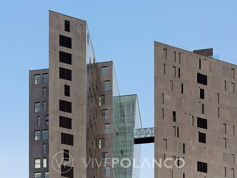 Complejo de edificios modernos de concreto con puente de vidrio conectando las estructuras en Campos Eliseos 200, Polanco