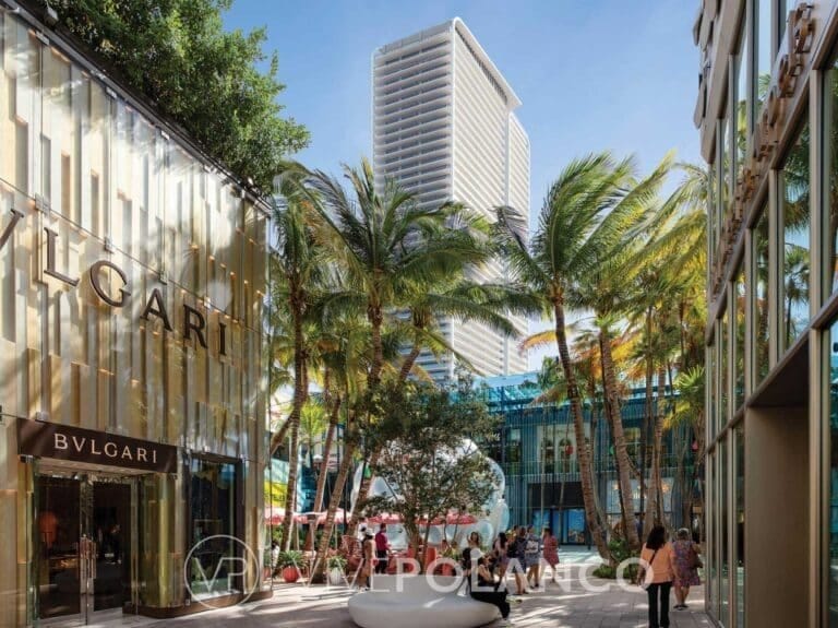 Calle peatonal con boutiques de lujo, palmeras y rascacielos residenciales al fondo en día soleado en Jean Georges Miami Tropic Residences, Polanco