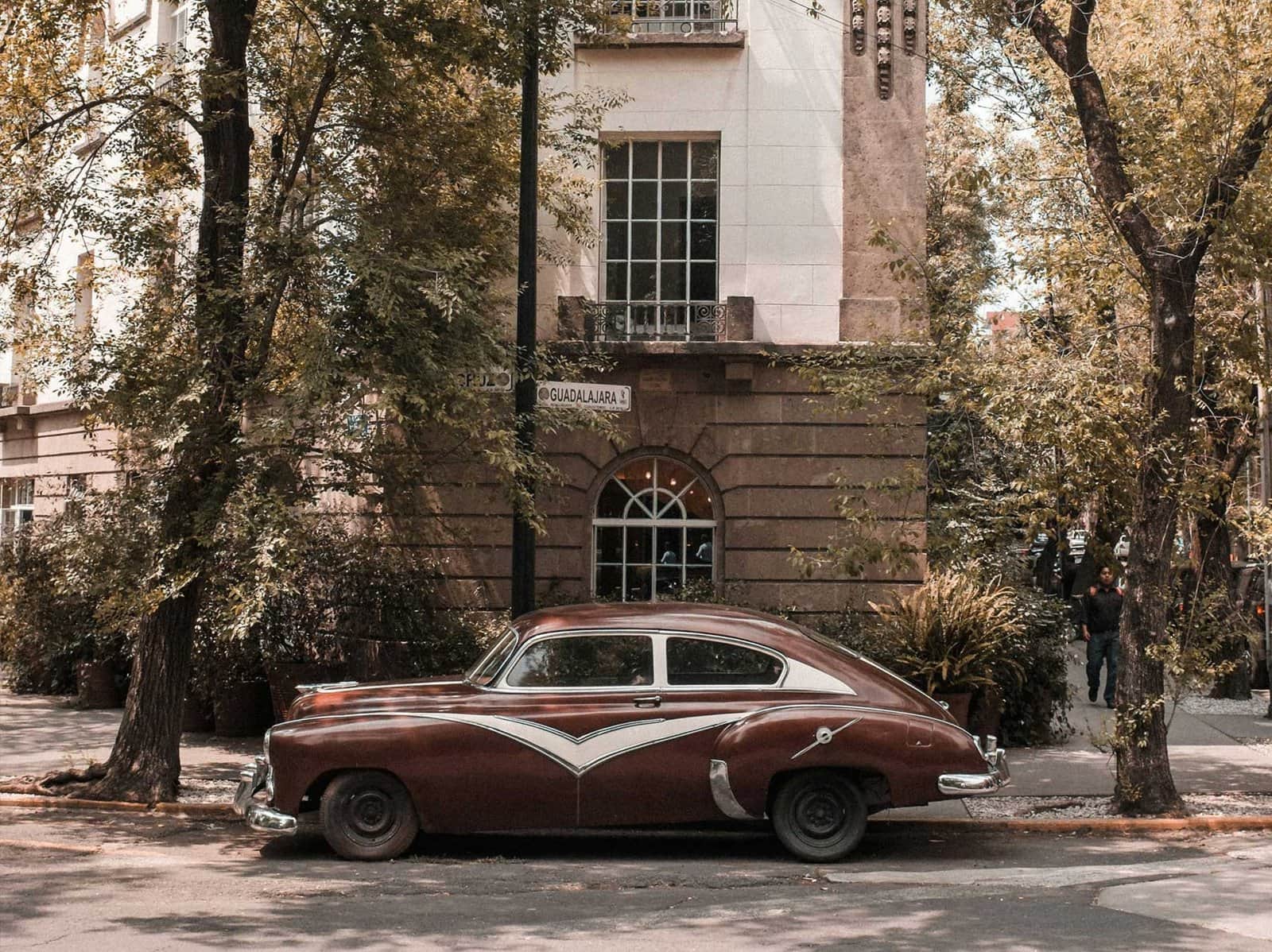Fachada art decó de un edificio en Condesa con un auto antiguo estacionado enfrente