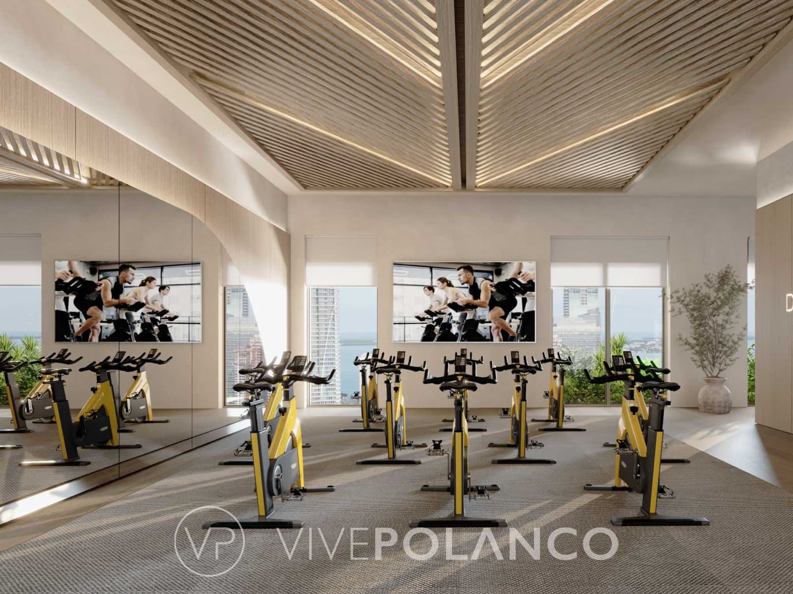 Gimnasio moderno en Parkside Brickell con bicicletas estáticas amarillas, espejos y vista urbana