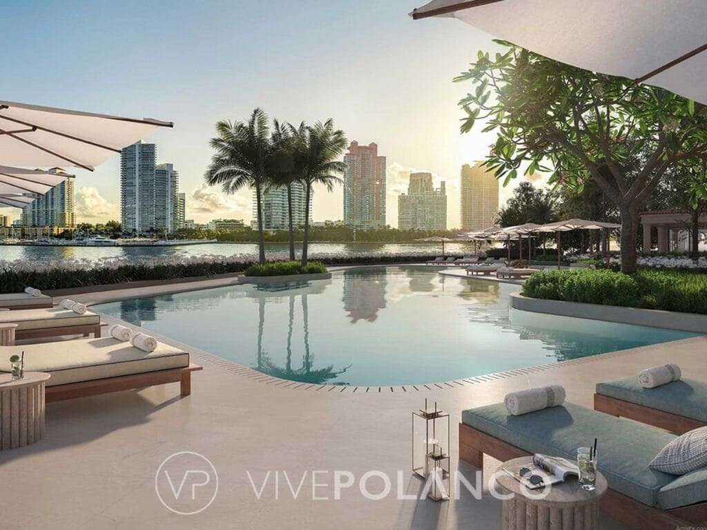 Área de alberca con camastros y sombrillas, rodeada de palmeras con vista a edificios residenciales en Six Fisher Island Miami, Polanco