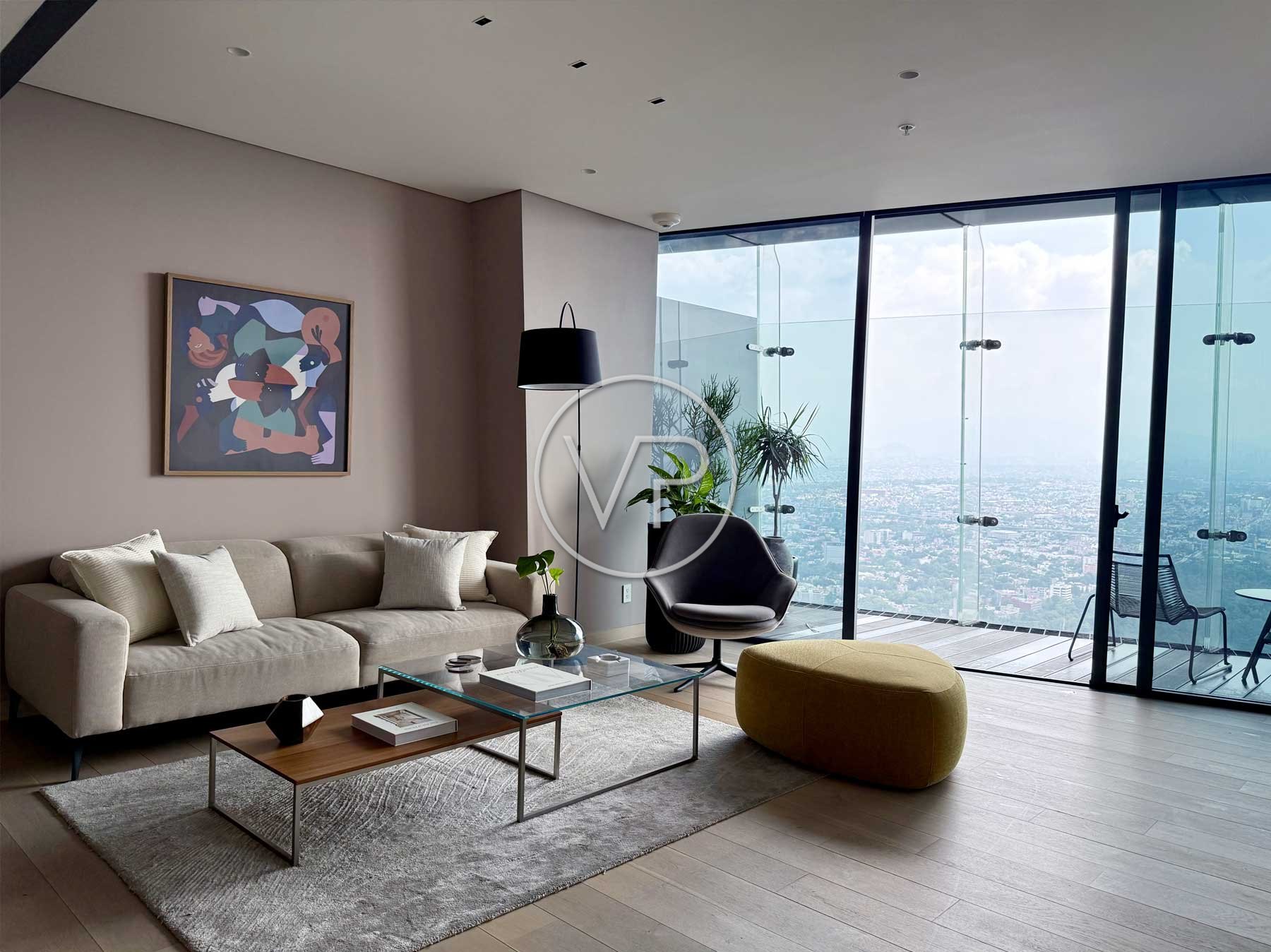 Sala con sofá beige, puff amarillo, mesa de centro redonda y ventanales con vista a la ciudad en Polanco