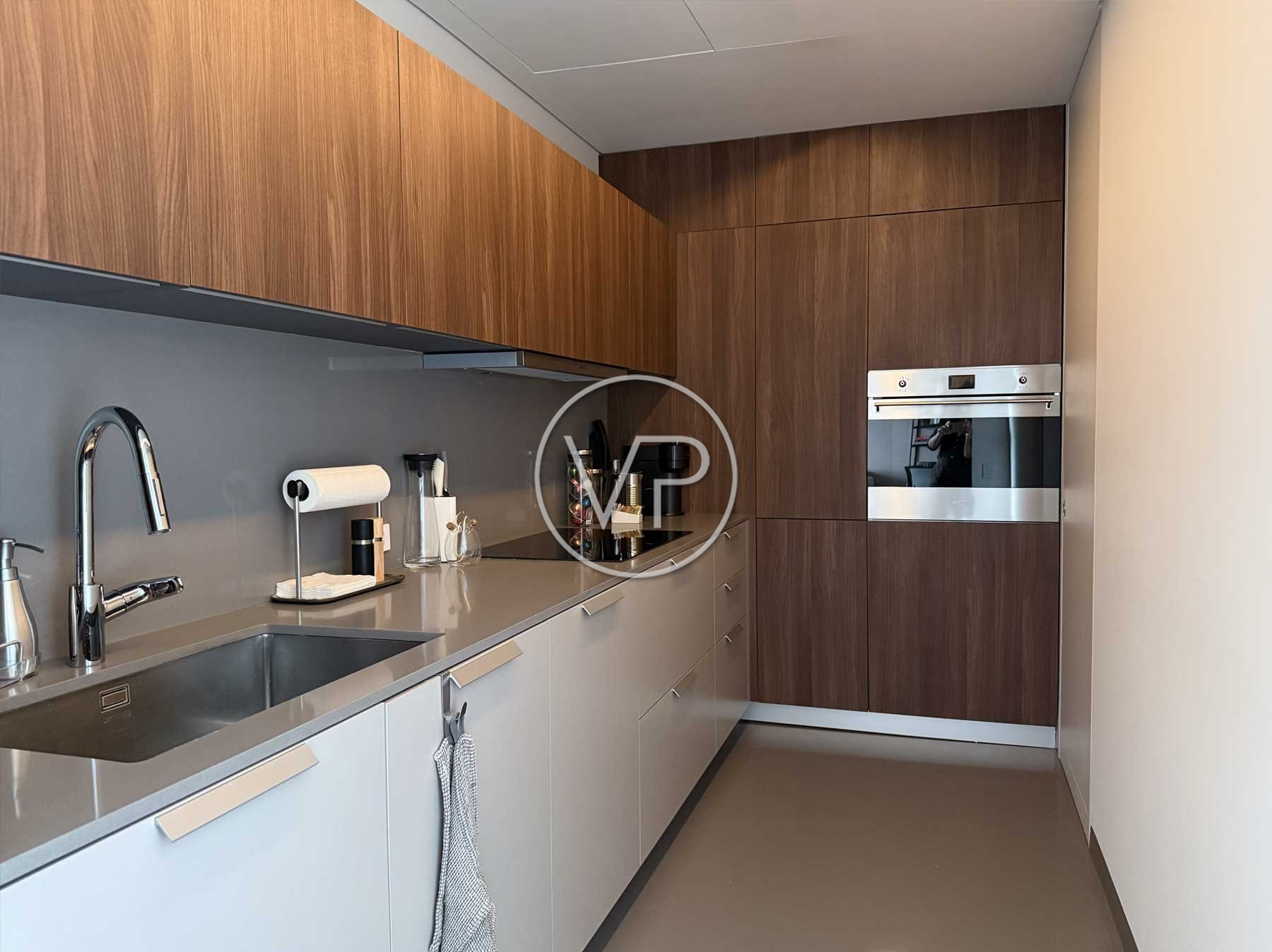 Cocina con gabinetes de madera, horno de acero inoxidable y cubierta gris en Ritz-Carlton Residences, Polanco