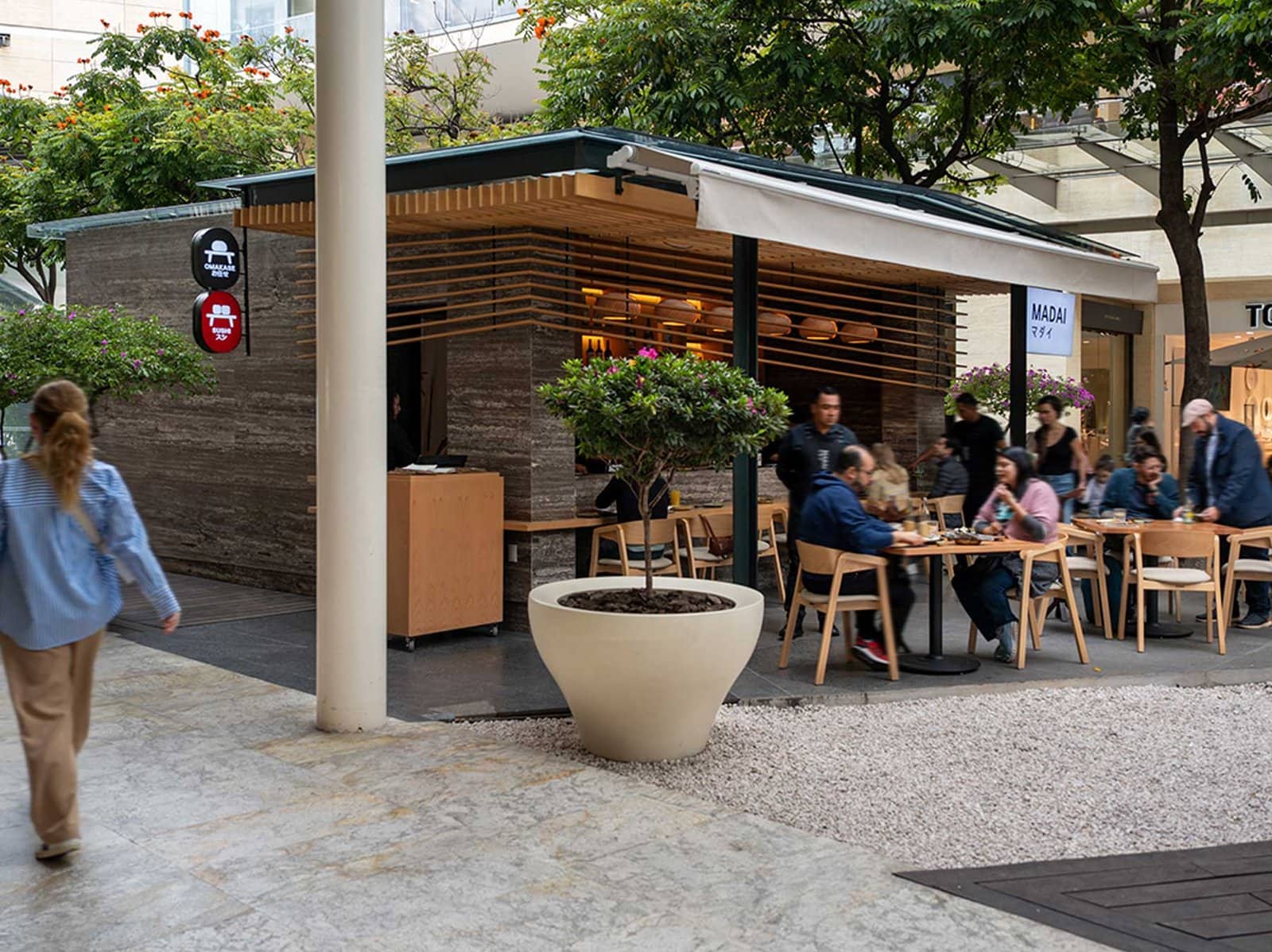 Área de restaurante con terraza al aire libre en Plaza Antara Polanco con mesas de madera y comensales