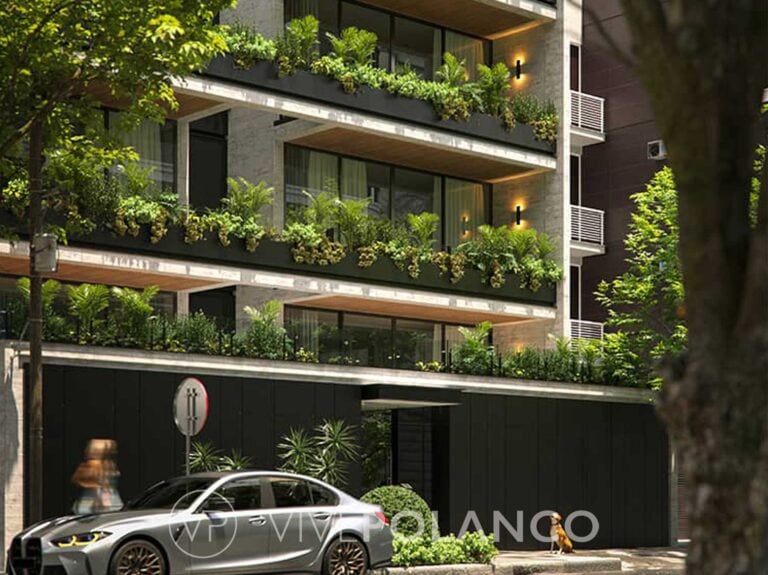 Fachada nocturna del edificio Aristóteles en Polanco con balcones verdes y auto BMW en acceso vehicular