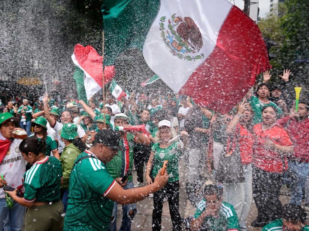 Aficionados mexicanos celebran en la calle con banderas tricolores durante la fiesta del Mundial 2026