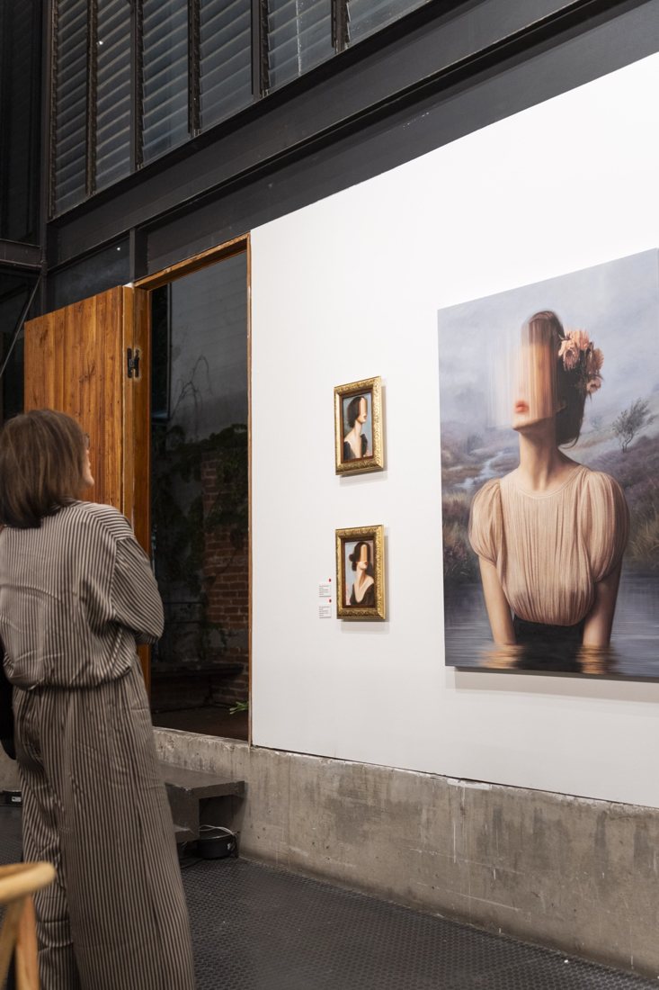 Dos retratos pequeños en marcos dorados junto a una obra de gran formato de JoCa