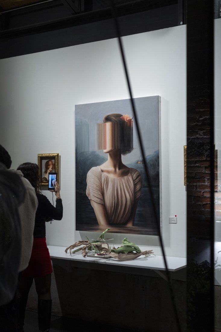 Una persona fotografía con su teléfono una obra de Echoes of Haworth durante la inauguración en Galera 32